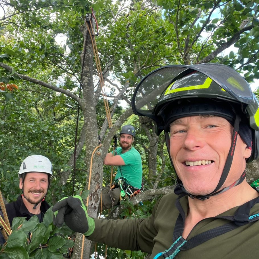Patrick Weihe mit seinem Netzwerk - stehen in Kletterausrüstung in einem Baum und lächeln in die Kamera.